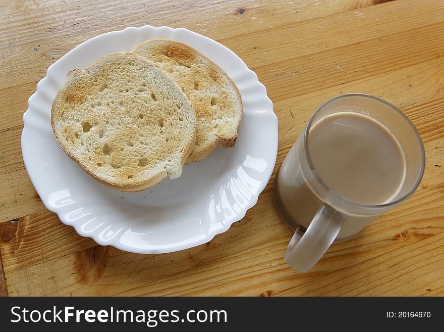 Cup of coffee with milk and two toasted bread slices, on whooden table. Cup of coffee with milk and two toasted bread slices, on whooden table