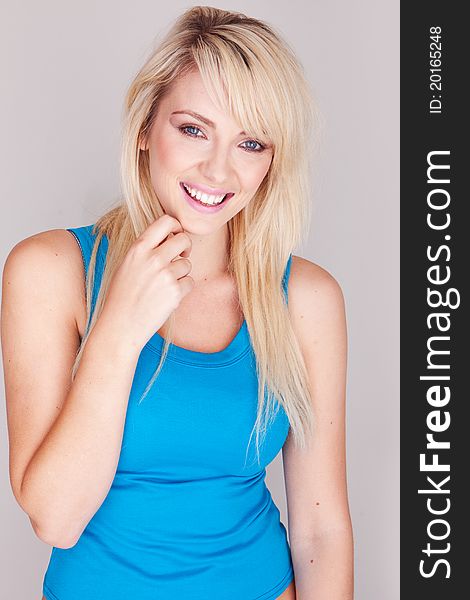Close up portrait of a attractive young blond woman wearing a blue top. Close up portrait of a attractive young blond woman wearing a blue top.