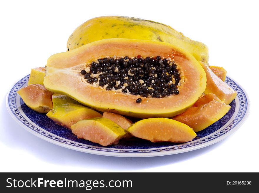 Close up view of papaya fruit sliced presented on a dish.