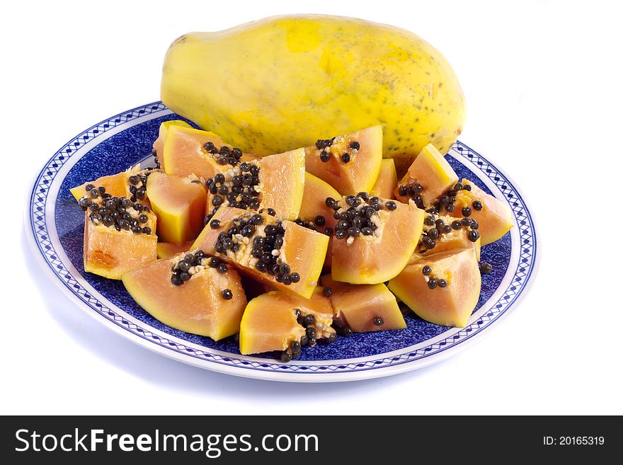 Close up view of papaya fruit sliced presented on a dish.