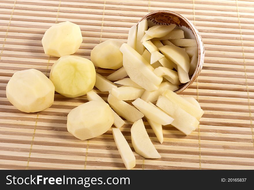 Close up view of some sliced potatoes on bamboo background.