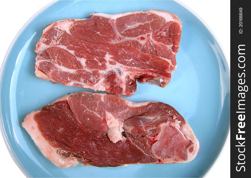 A photo of two raw lamb chops lying next to each other.