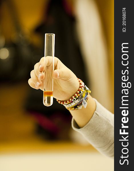 Close up view of a student of chemistry holding a test tube. Close up view of a student of chemistry holding a test tube.