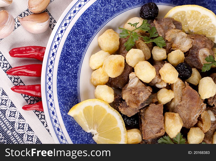 Close up view of a Portuguese meal of cooked meat with potatoes.