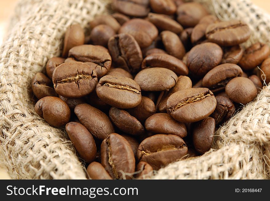 Roasted coffee beans in sacking bag. Selective focus.