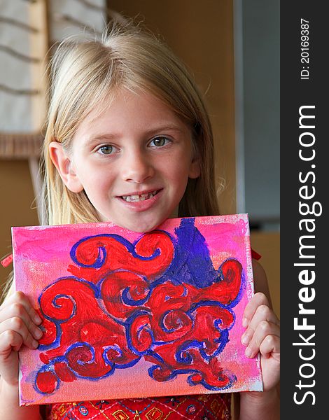 A young girl shows off her colorful painting. A young girl shows off her colorful painting