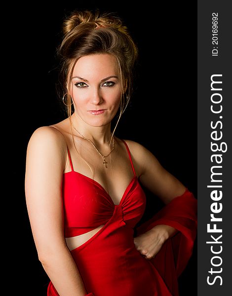 Beautiful woman with a passionate look in the red dress on a black background isolated. Beautiful woman with a passionate look in the red dress on a black background isolated