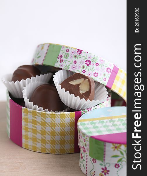 Chocolate truffles in colorful gift box on white background. Chocolate truffles in colorful gift box on white background.