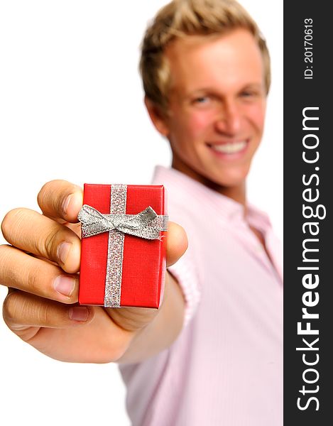 Happy blonde man holding a present for valentines day; selective focus on box. Happy blonde man holding a present for valentines day; selective focus on box