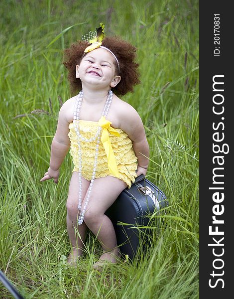 Happy little toddler girl wearing a yellow petti romper. Happy little toddler girl wearing a yellow petti romper