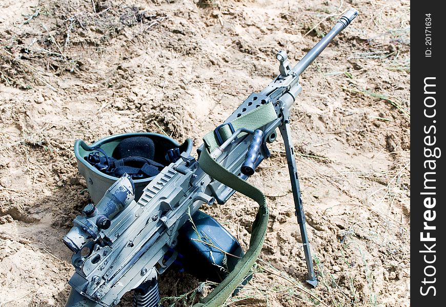 Soldier helmet and assault rifle on the sand. Soldier helmet and assault rifle on the sand