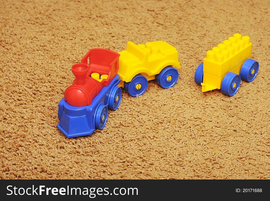 Small toy train on yellow background
