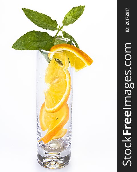 Slices of orange and mint in the glass isolated over white. Slices of orange and mint in the glass isolated over white