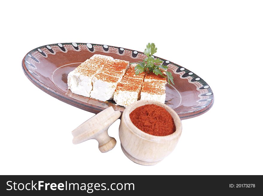 Bulgarian white cheese with paprika into a plate isolated on white. Bulgarian white cheese with paprika into a plate isolated on white