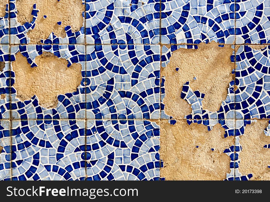 Close up view of a broken tiled wall of small azulejo.