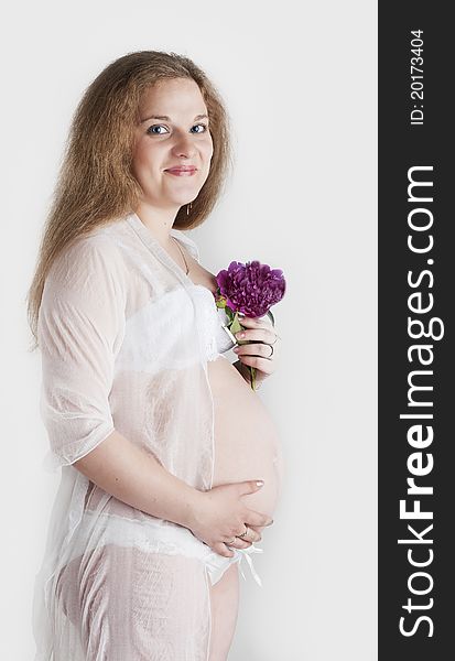 The pregnant woman has control over a basis for bouquet drawing up and smiling. The pregnant woman has control over a basis for bouquet drawing up and smiling