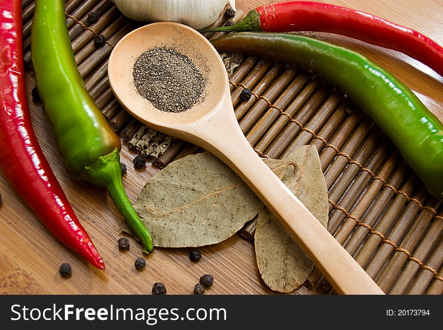 Some kinds of pepper and bay leaf on wooden plate. Some kinds of pepper and bay leaf on wooden plate