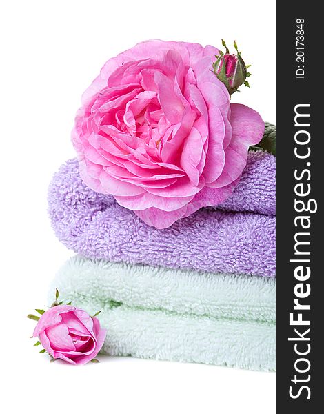 Stacked colorful towels with roses flower. Isolated over white