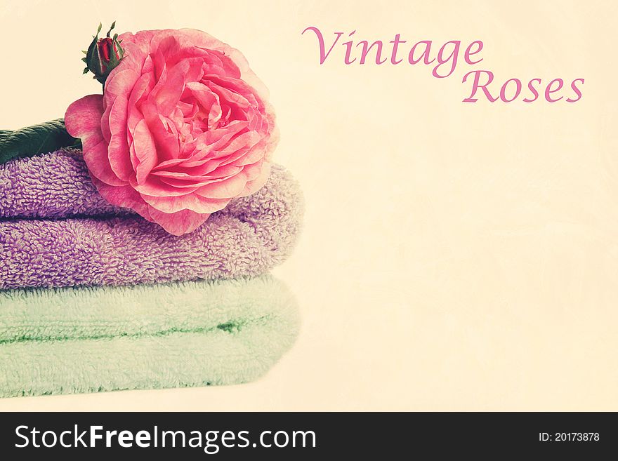 Stacked colorful towels with roses flower. Isolated over white