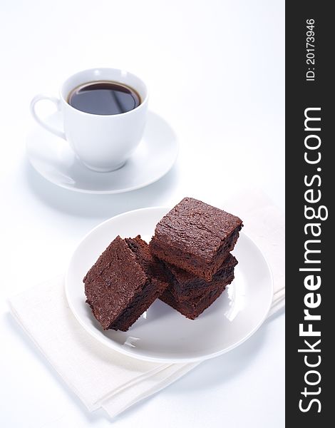 Chocolate brownies on the cake stand and cup of cofee