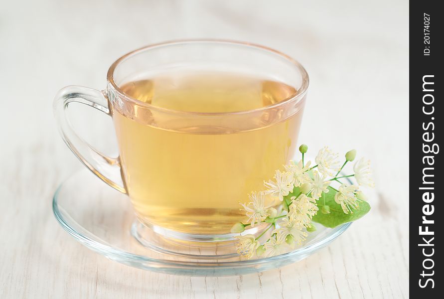 Cup of tea and linden flowers on wooden background. Cup of tea and linden flowers on wooden background