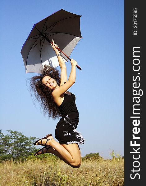 Happy girl jumping with umbrella