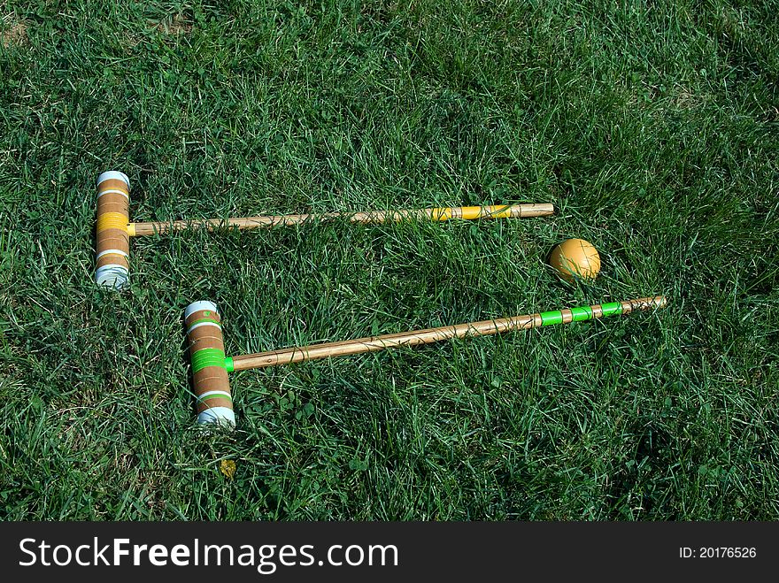 Two croquet mallets on green grass.