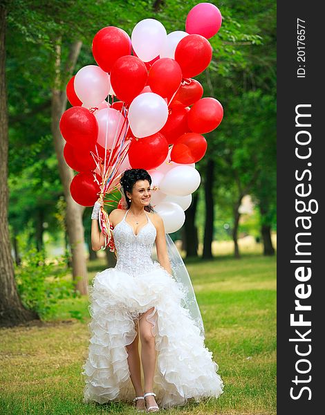 Bride with balloons in park