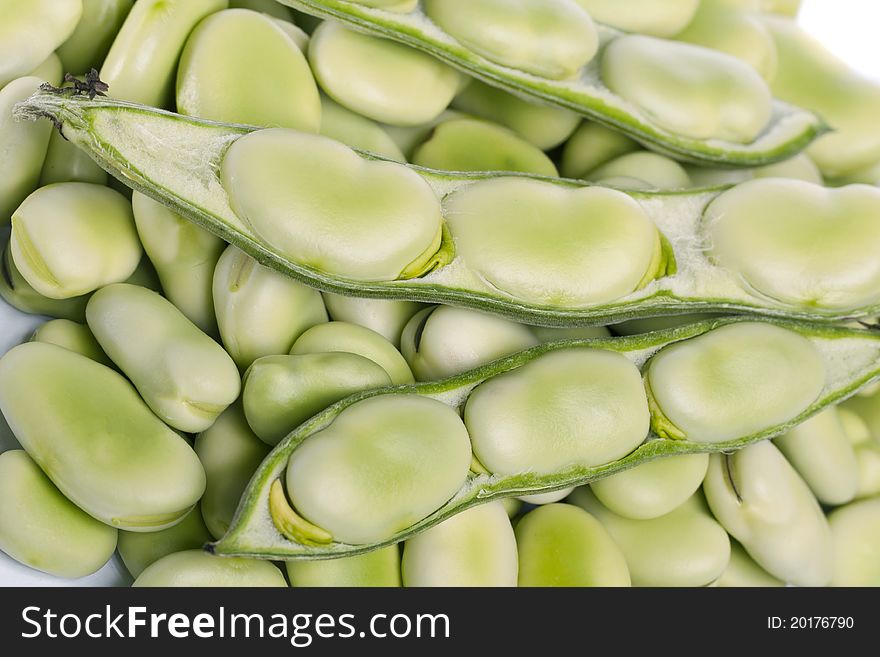 Close up view of some broad beans on a white background.