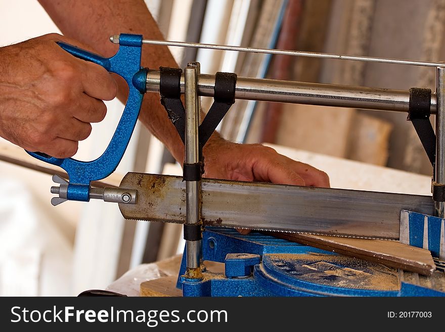 A man is cutting wood with a saw