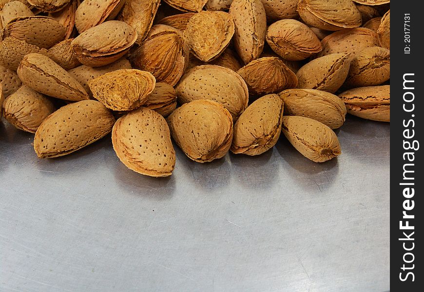 A shot of a bunch of almonds with its shell on a tray