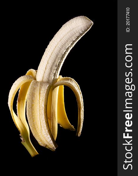 Close up view of peeled banana isolated on a black background. Close up view of peeled banana isolated on a black background.