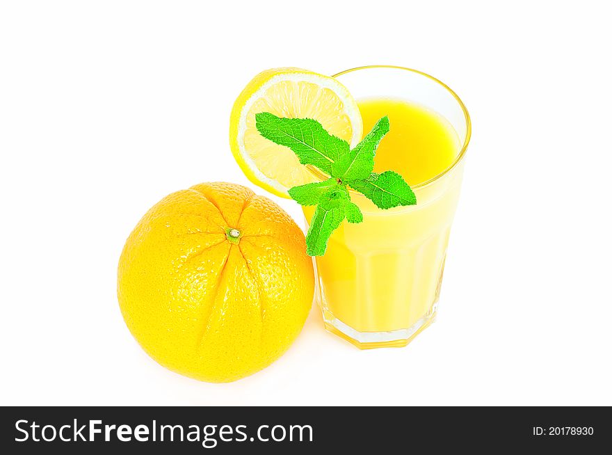 Fresh orange and glass of orange juice decorated with lemon slice and mint. Fresh orange and glass of orange juice decorated with lemon slice and mint