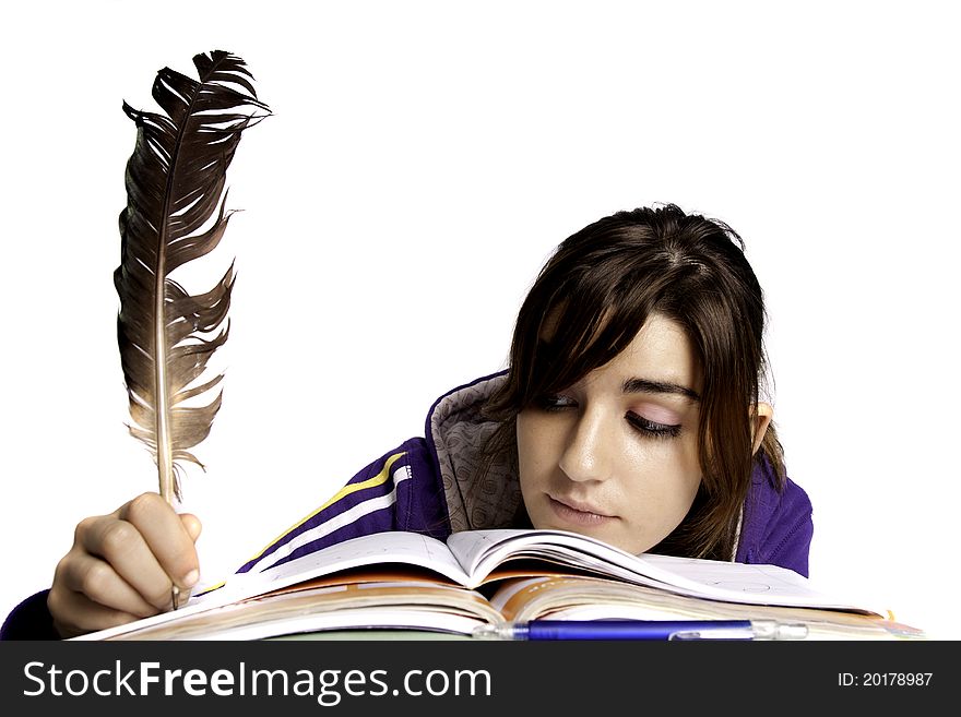 View of a teenager school girl writing on the book with a feather pen. View of a teenager school girl writing on the book with a feather pen.