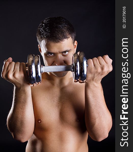 Young athlete is posing with weights. Young athlete is posing with weights