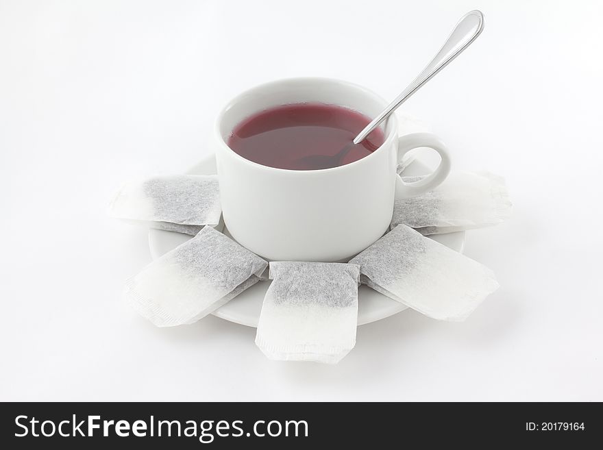 A cup of tea with teabags and spoon isolated on white. A cup of tea with teabags and spoon isolated on white