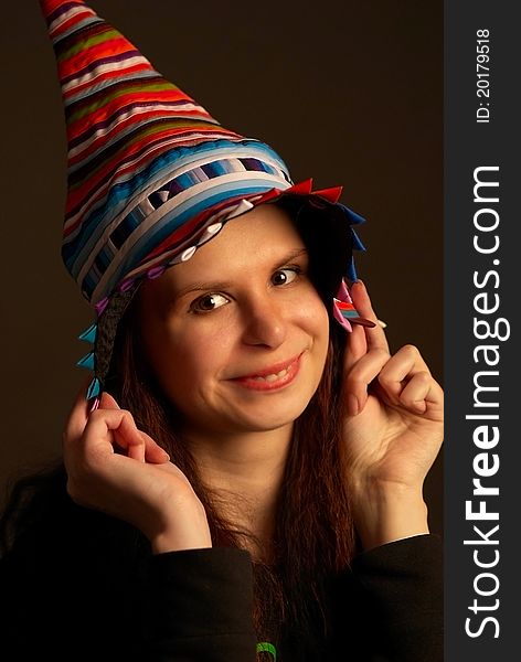 Studio portrait of young happy girl in multicolor fool's cap. Studio portrait of young happy girl in multicolor fool's cap