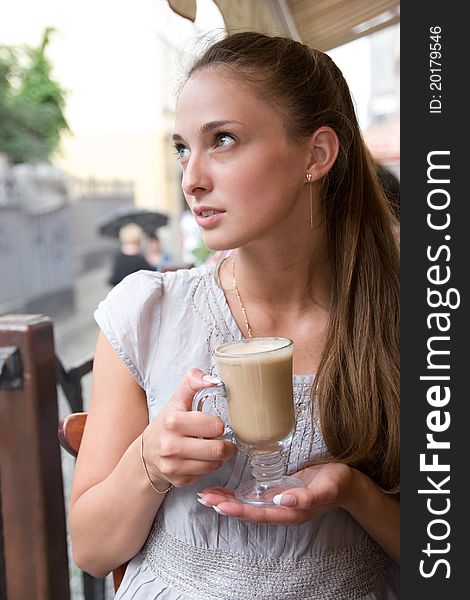Portrait of charming dreaming woman with coffee in outdoor city cafe. Portrait of charming dreaming woman with coffee in outdoor city cafe