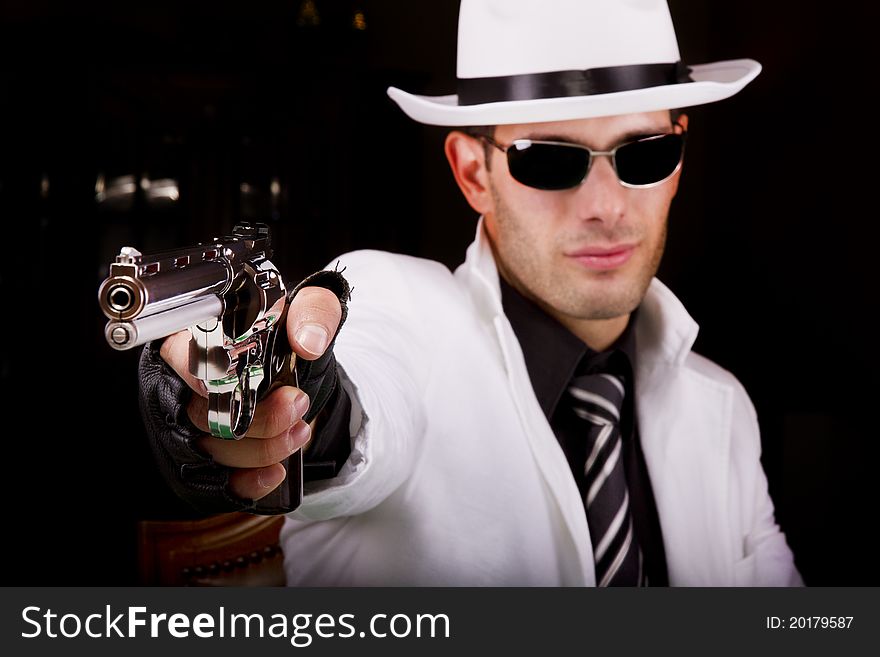 View of a white suit gangster man holding a gun. View of a white suit gangster man holding a gun.