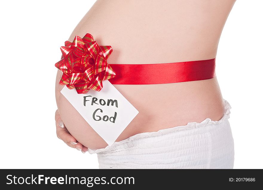 Pregnant woman's belly tied with a red ribbon with caption From God isolated on white. Pregnant woman's belly tied with a red ribbon with caption From God isolated on white