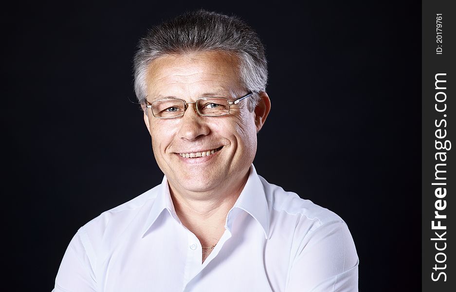 Portrait of successful business man standing on black background. Portrait of successful business man standing on black background