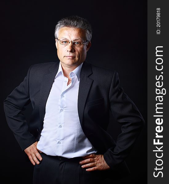 Portrait of successful business man standing on black background. Portrait of successful business man standing on black background