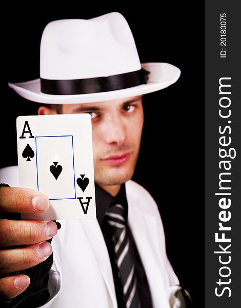 View of a white suit man with hat holding an ace card.