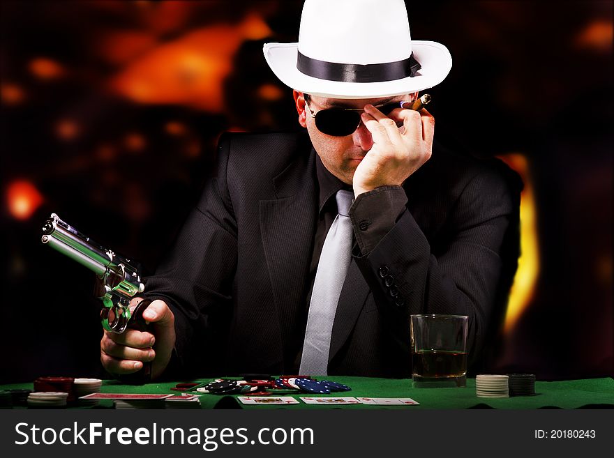 View of a gangster man playing some cards and poker. View of a gangster man playing some cards and poker.