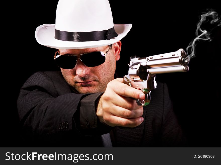 View of a white suit gangster man holding a gun. View of a white suit gangster man holding a gun.