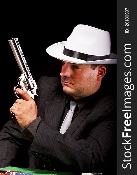 View of a dark suit gangster man holding a gun. View of a dark suit gangster man holding a gun.