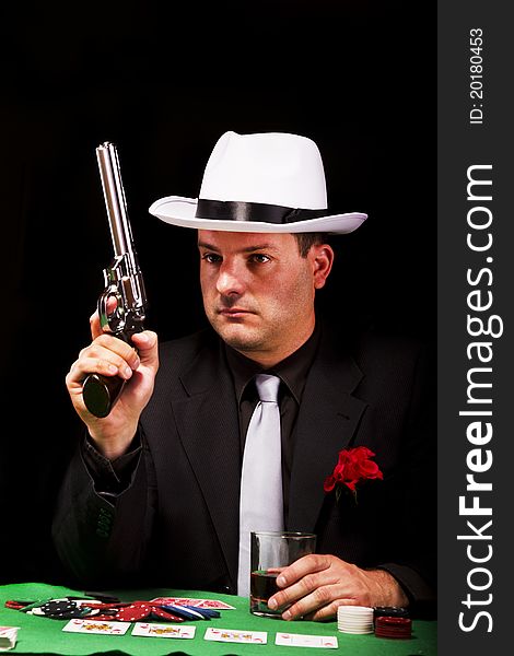 View of a dark suit gangster man holding a gun. View of a dark suit gangster man holding a gun.