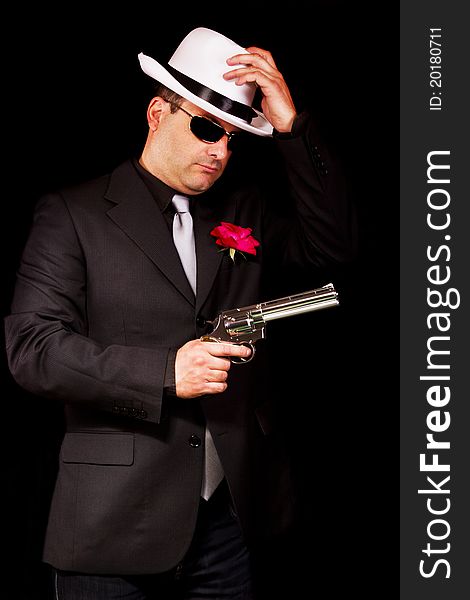 View of a dark suit gangster man holding a gun. View of a dark suit gangster man holding a gun.