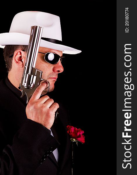 View of a dark suit gangster man holding a gun. View of a dark suit gangster man holding a gun.