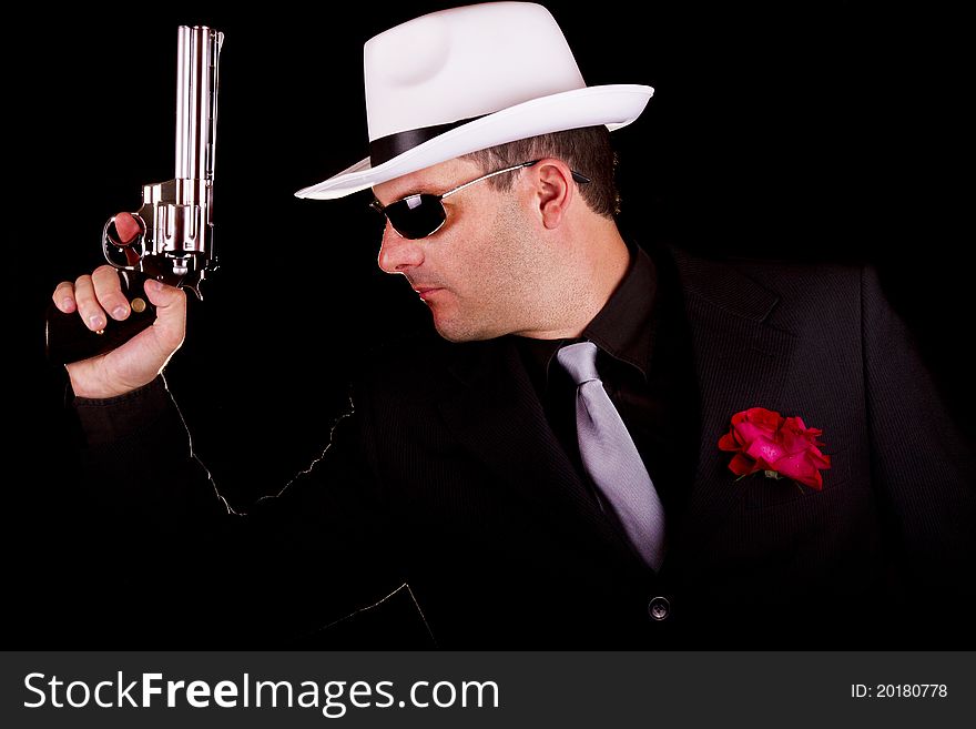 View of a dark suit gangster man holding a gun. View of a dark suit gangster man holding a gun.